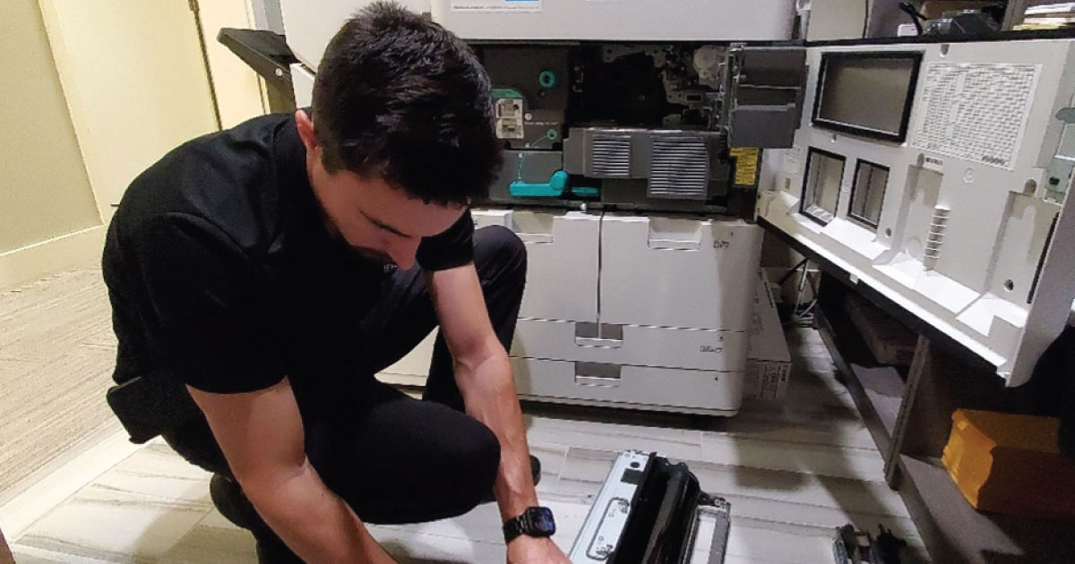 Technician servicing a printer to ensure optimal performance